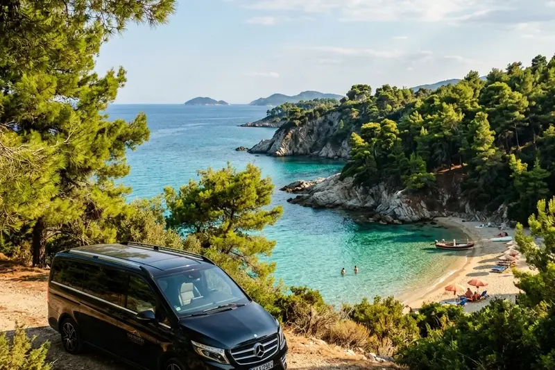 Black private transfer minivan Mercedes V-Class parked above a beautiful wild sandy beach cove in Sithonia, Halkidiki